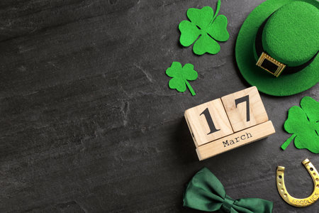 Leprechaun's hat, block calendar and St. Patrick's day decor on black background, flat lay. Space for textの写真素材
