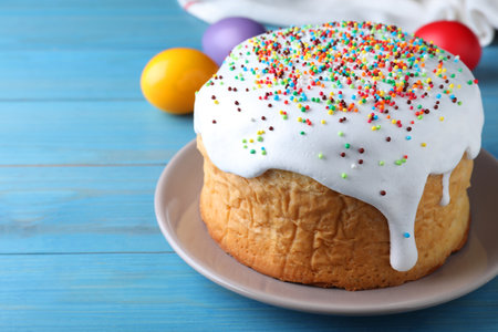 Easter cake and color eggs on blue wooden table, space for textの写真素材