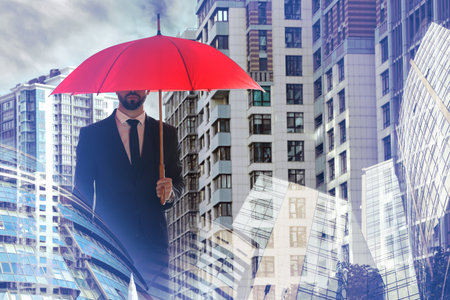 Businessman with umbrella in city center. insurance conceptの写真素材