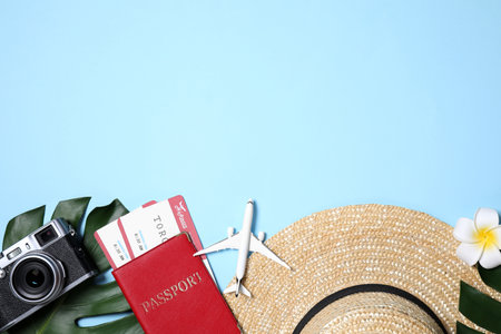 Flat lay composition with passport and camera on light blue background. Space for textの写真素材