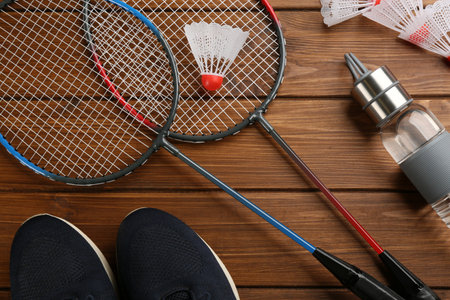 Rackets, sportswear and bottle on wooden table, flat lay. playing badmintonの写真素材