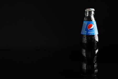 MYKOLAIV, UKRAINE - FEBRUARY 08, 2021: Glass bottle of Pepsi with water drops on black background. Space for textのeditorial素材