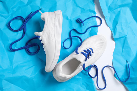 Pair of stylish shoes with laces on light blue paper, flat layの写真素材