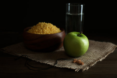 Millet, apple, water and crucifix on wooden table. Great Lent seasonの写真素材
