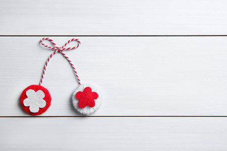 Traditional martisor on white wooden background, top view with space for text. Beginning of spring celebrationの写真素材