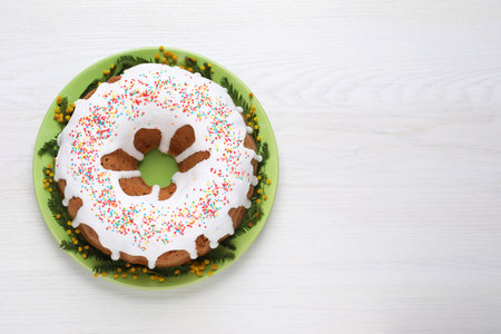 Glazed Easter cake with sprinkles on white wooden table, top view. Space for textの写真素材