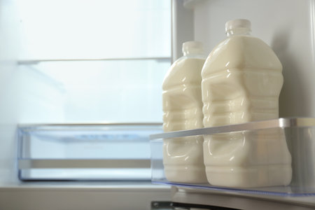 Gallons of milk in refrigerator, closeup. Space for textの写真素材