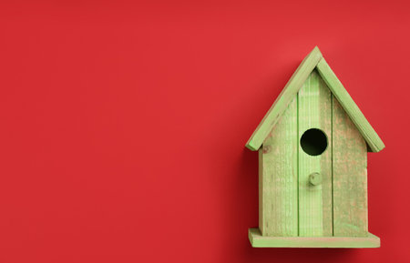 Beautiful bird house on red background, top view. Space for textの写真素材