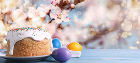 Traditional Easter cake and eggs on wooden table outdoors, space for text. banner design