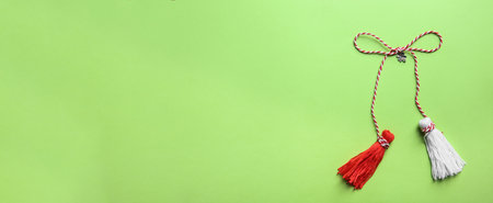 Traditional martisor on green background, top view with space for text. Beginning of spring celebrationの写真素材