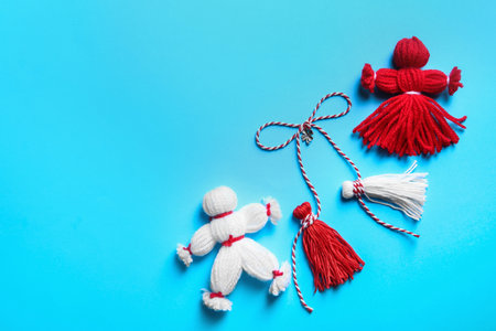 Traditional martisoare on light blue background, flat lay with space for text. Beginning of spring celebrationの写真素材