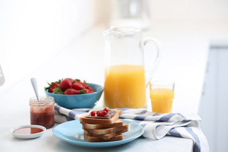 Toasted bread with chocolate spread and cranberries on white table in kitchenの写真素材