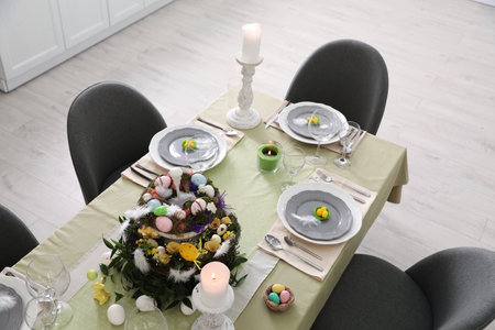 Beautiful Easter table setting with burning candles indoors, above viewの写真素材