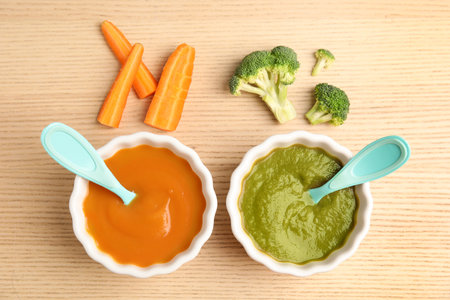 Flat lay composition with healthy baby food and ingredients on wooden tableの写真素材