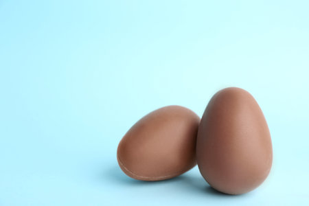 Sweet chocolate eggs on light blue background. Space for textの写真素材