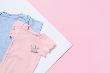 Cute baby clothes on color background, flat lay. Space for textの写真素材