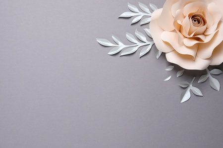 Beautiful beige flower and branches made of paper on gray background, flat lay. Space for textの写真素材