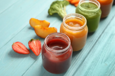 Healthy baby food and ingredients on light blue wooden tableの写真素材
