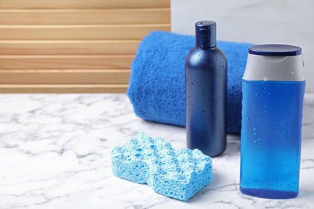 Cosmetic products and towel on white marble table. Men's hygiene