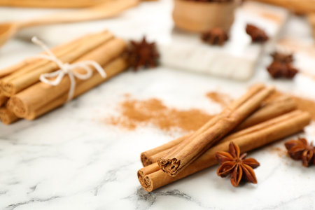 Aromatic cinnamon and anise on white marble table, closeup. Space for textの写真素材
