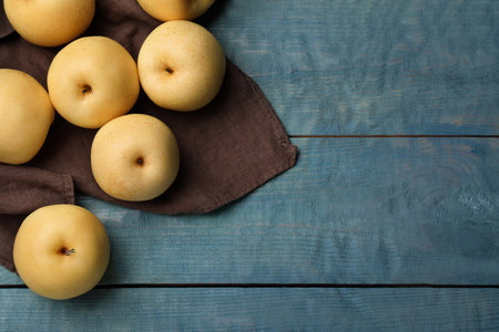 Ripe apple pears on blue wooden table, flat lay. Space for textの写真素材
