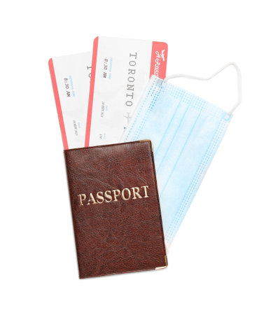 Passport, tickets and protective mask on white background, top view. Travel during quarantineの写真素材