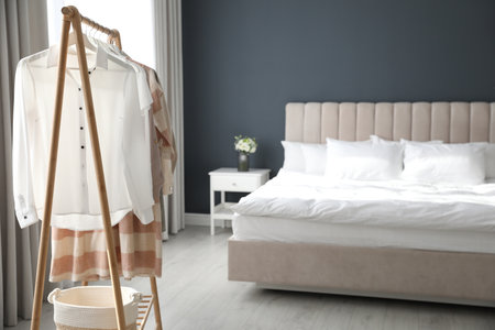 Different stylish clothes on rack in the roomの写真素材