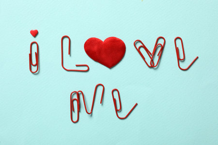 Phrase I Love Me made of clips and red hearts on turquoise background, flat layの写真素材