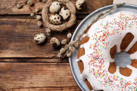 Glazed Easter cake with sprinkles and quail eggs on wooden table, flat lay. Space for textの写真素材