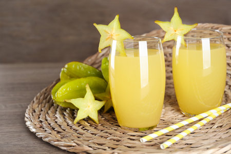 Delicious carambola juice and fresh fruits on wooden table. Space for textの写真素材