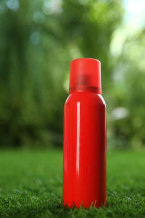 Bottle of insect repellent spray on green grassの写真素材