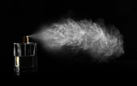 Woman spraying luxury perfume on black background, closeupの写真素材