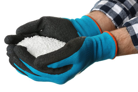 Man holding ammonium nitrate pellets on white background, closeup. mineral fertilizer