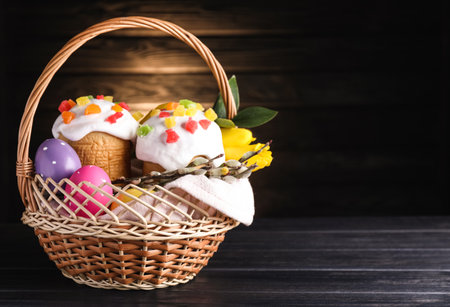 Traditional Easter cakes in wicker basket on dark background. Space for textの写真素材