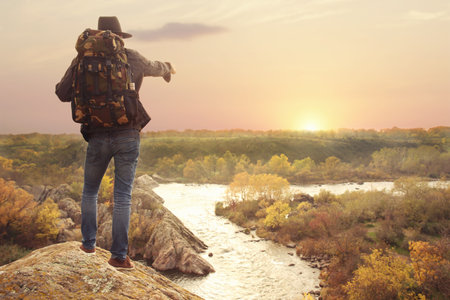 Man enjoying beautiful nature near mountain river, back viewの写真素材