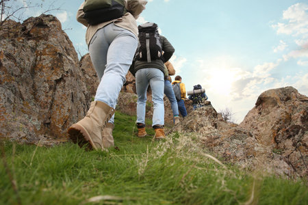 Group of hikers with backpacks climbing up mountains, closeupの写真素材