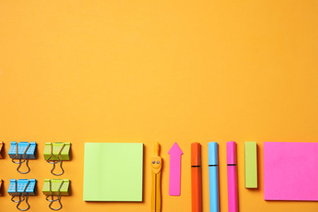 different school stationery on orange background, flat lay. Space for textの写真素材