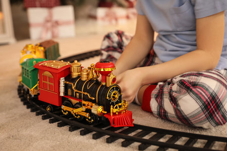 Little boy playing with colorful train toy in room decorated for Christmas, closeupの写真素材