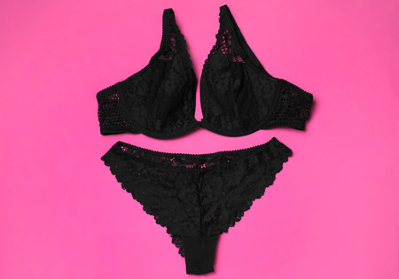 Set of black lace lingerie on pink background, flat layの写真素材