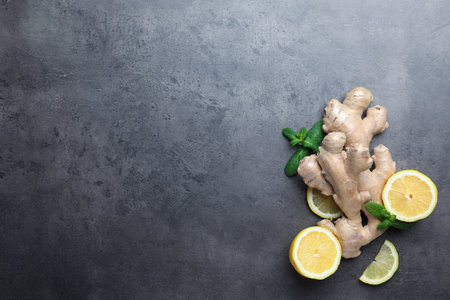Fresh lemon, ginger and mint on gray table, flat lay. Space for text