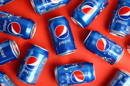 MYKOLAIV, UKRAINE - FEBRUARY 08, 2021: Cans of Pepsi on red background, flat lay
