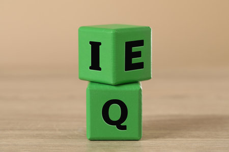 Green cubes with letters E, I and Q on wooden tableの写真素材
