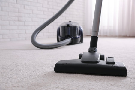 Modern vacuum cleaner on carpet indoors, closeup. Space for textの写真素材