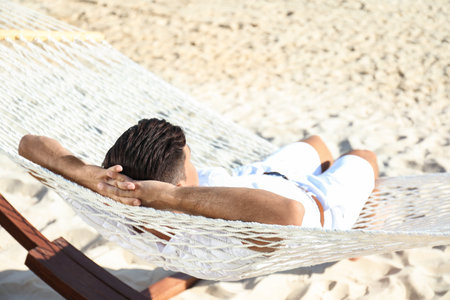 Man relaxing in hammock on the beach. summer holidaysの写真素材