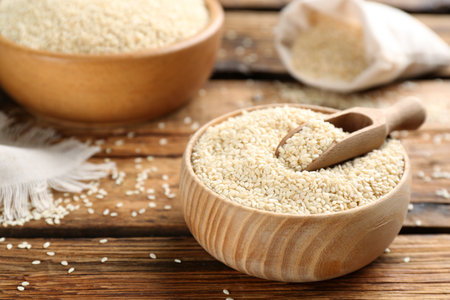 Bowl of white sesame seeds on wooden tableの写真素材