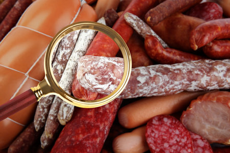 Magnifying glass focusing on sausage. food controlの写真素材