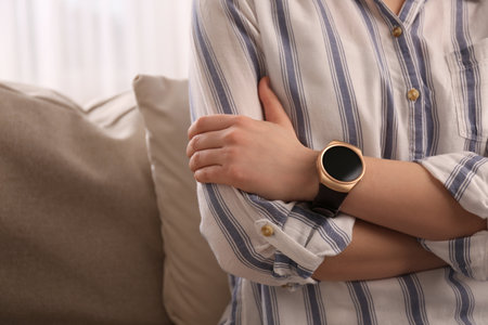 Young woman with smart watch at home, closeupの写真素材