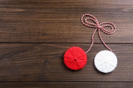 Traditional martisor on wooden background, top view with space for text. Beginning of spring celebrationの写真素材