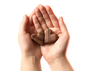 Woman holding heart shaped chocolate candies on white background, closeupの写真素材