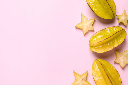 Delicious carambola fruits on pink background, flat lay. Space for textの写真素材